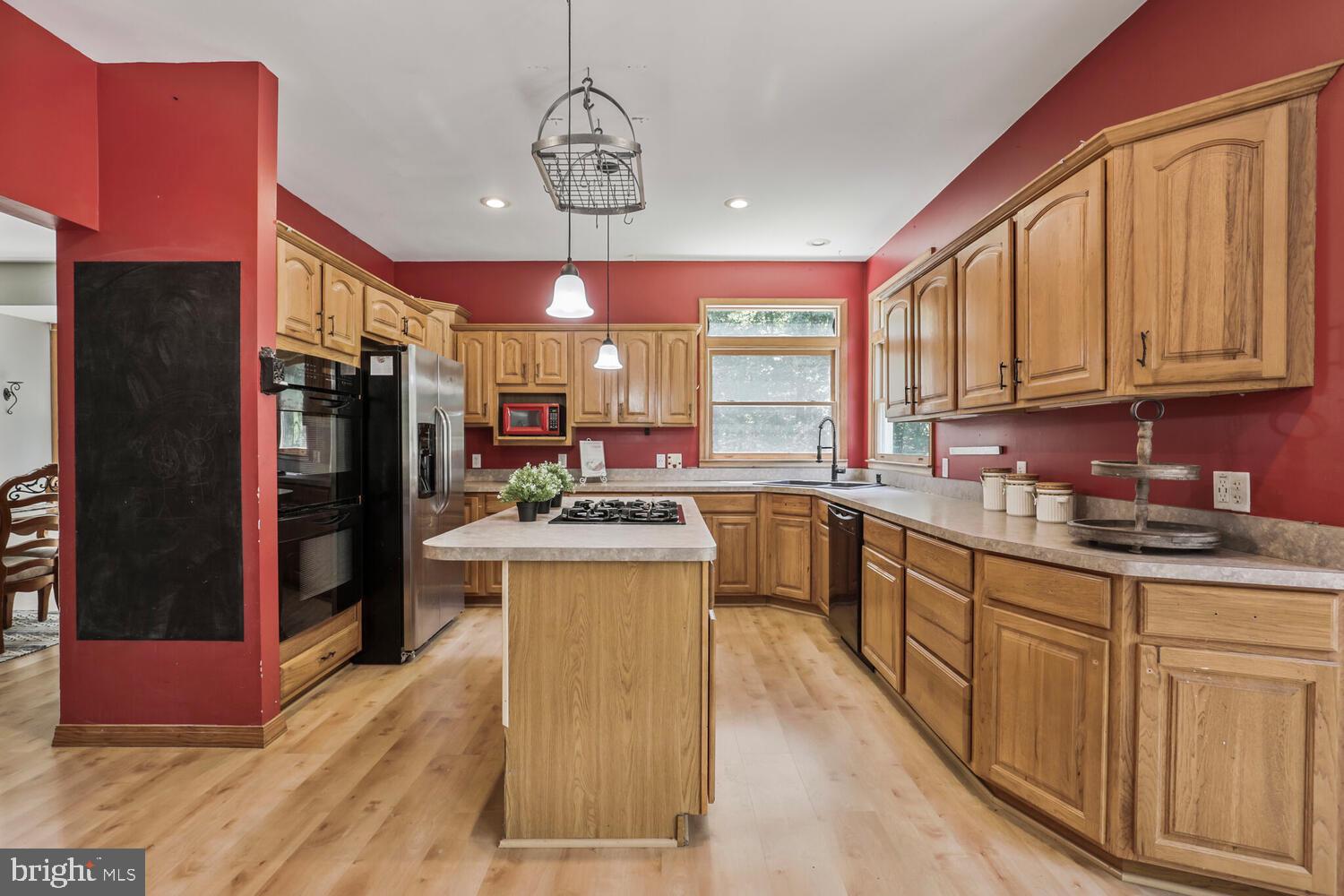 1761 Buckner Road Bumpass, VA 23024 - Photo 19 of 43 a kitchen with stainless steel appliances granite countertop a refrigerator a sink dishwasher a stove and a dining table with wooden floor