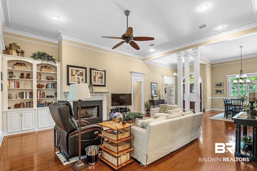 29976 Dolive Ridge Daphne, AL 36527 - Photo 18 of 58 Living room with crown molding, ceiling fan with notable chandelier, hardwood / wood-style flooring, and ornate columns