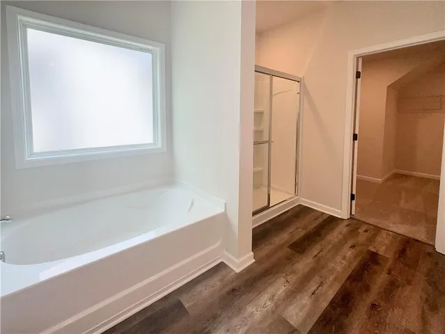 an empty room with a chandelier fan and windows