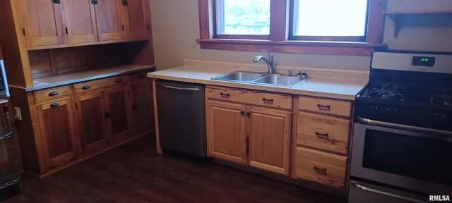 a kitchen with stainless steel appliances granite countertop a sink stove and cabinets