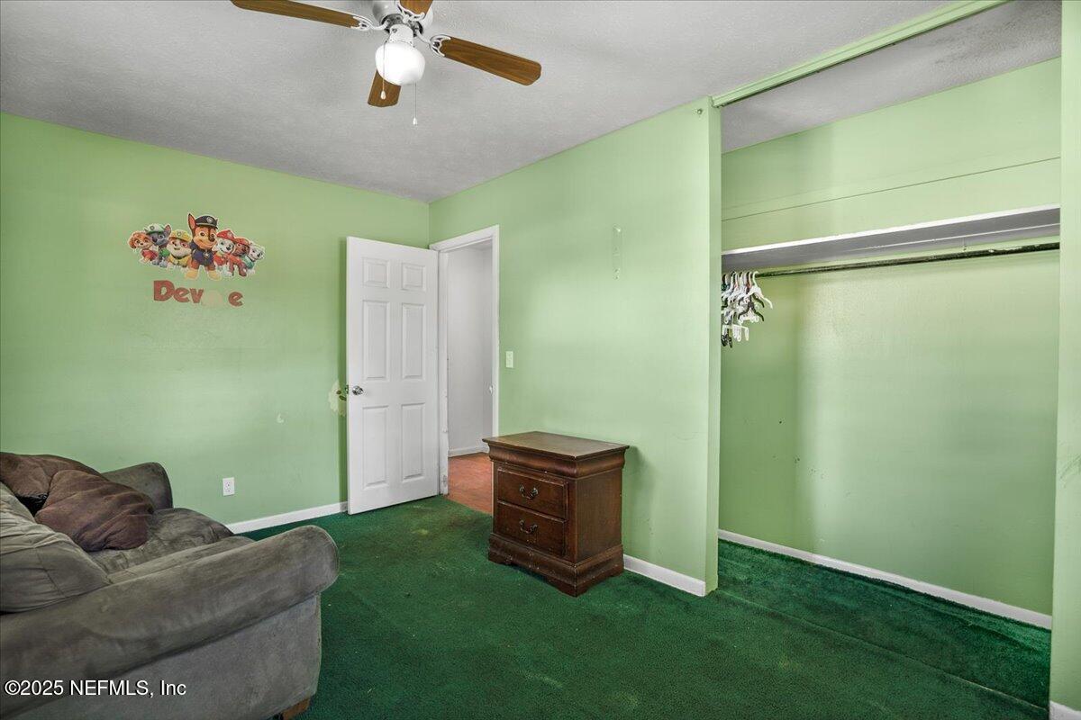 8514 Oak Leaf Road Jacksonville, FL 32208 - Photo 12 of 23 a living room with a couch and a ceiling fan