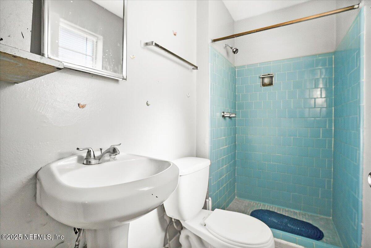8514 Oak Leaf Road Jacksonville, FL 32208 - Photo 18 of 23 a bathroom with a sink a toilet and shower