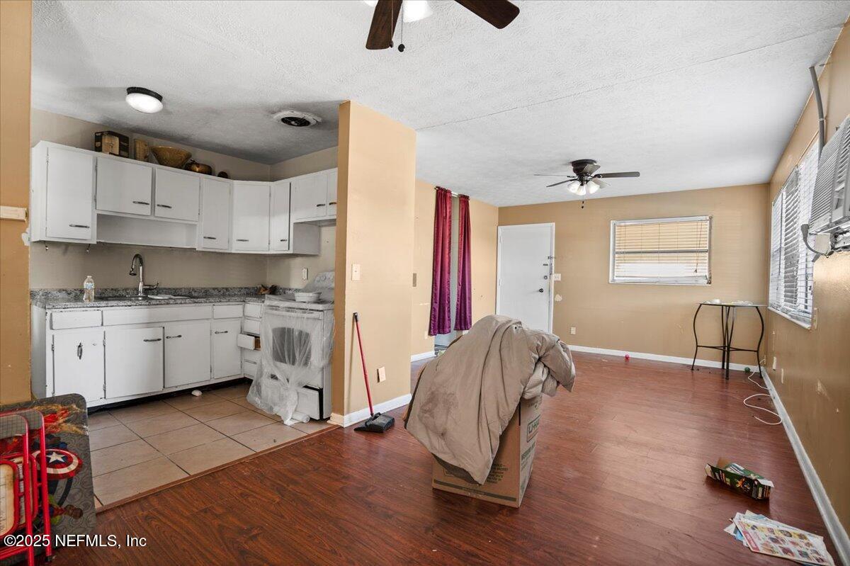 8514 Oak Leaf Road Jacksonville, FL 32208 - Photo 6 of 23 a kitchen with stainless steel appliances granite countertop a stove a sink a refrigerator and white cabinets with wooden floor