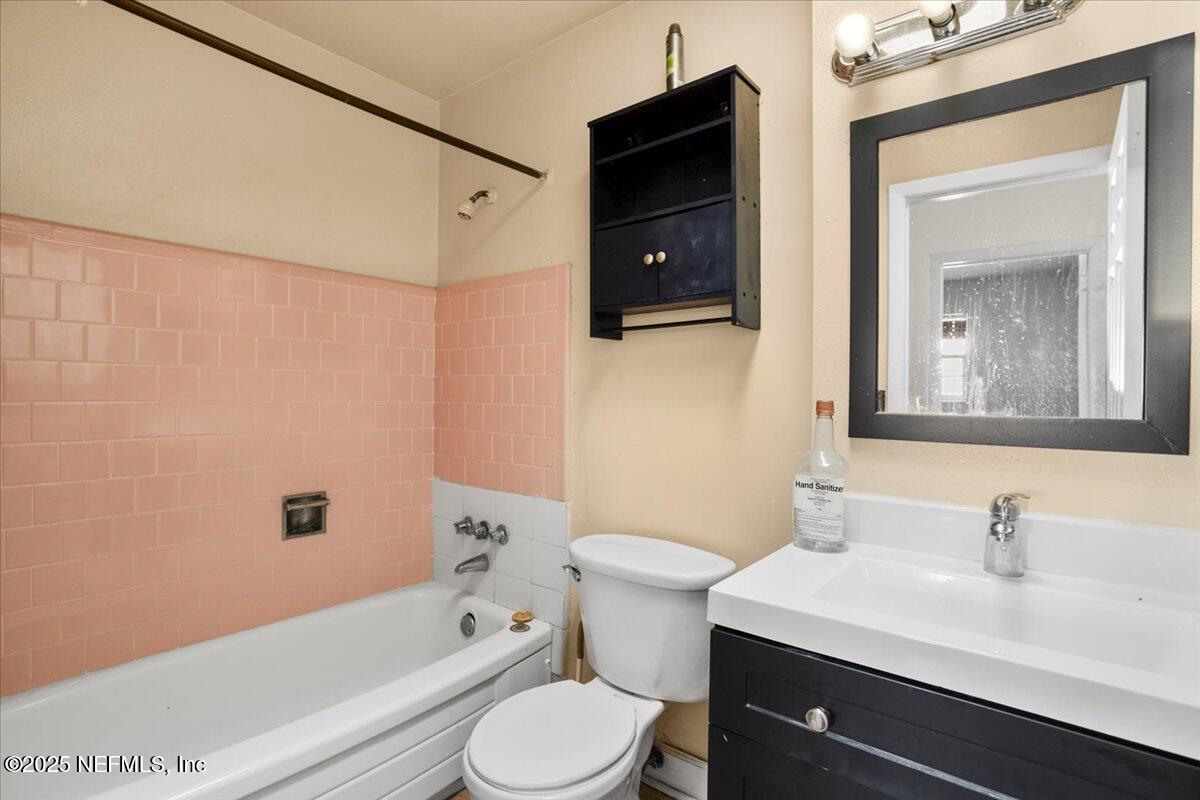 8514 Oak Leaf Road Jacksonville, FL 32208 - Photo 9 of 23 a bathroom with a sink a toilet a mirror and bathtub