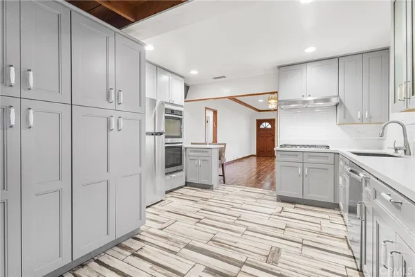 a kitchen with white cabinets and appliances