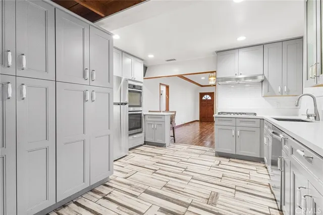 a kitchen with white cabinets and appliances