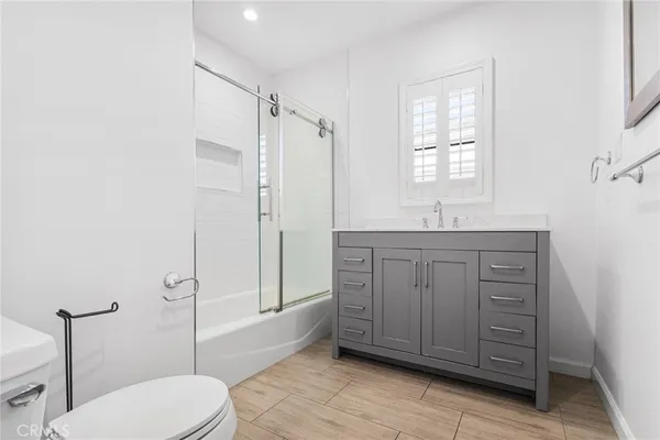 a bathroom with a granite countertop sink toilet and shower