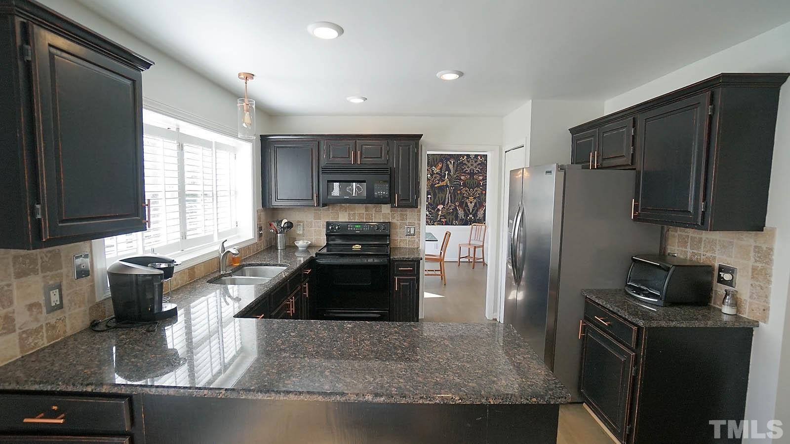 8300 Grey Abbey Place Raleigh, NC 27615 - Photo 4 of 34 Updated kitchen with granite counters, tile backsplash and new flooring.