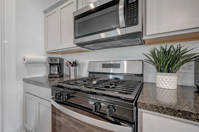 a kitchen with stainless steel appliances granite countertop a stove and a microwave
