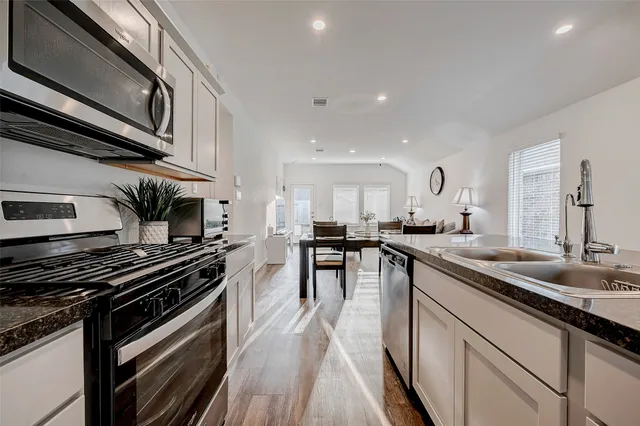 a kitchen with stainless steel appliances kitchen island granite countertop a stove and a sink