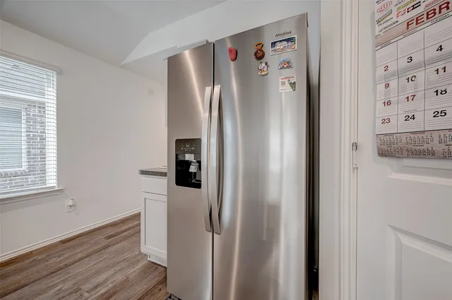 a view of a kitchen with refrigerator and window