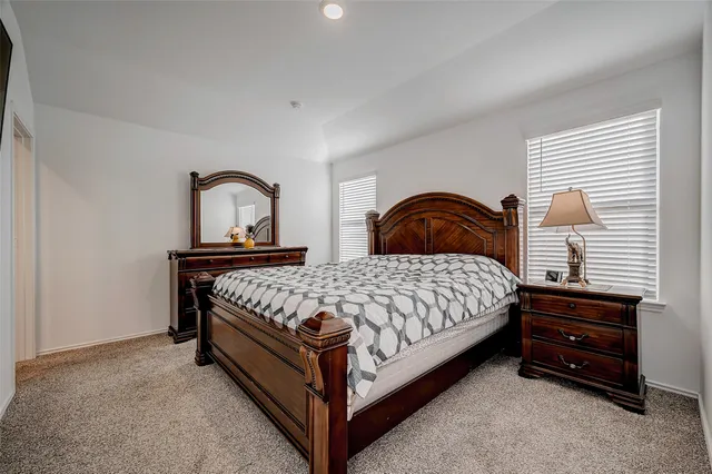 a bed sitting in a bedroom next to a window with a dresser