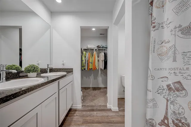 a bathroom with a granite countertop sink a mirror and shower