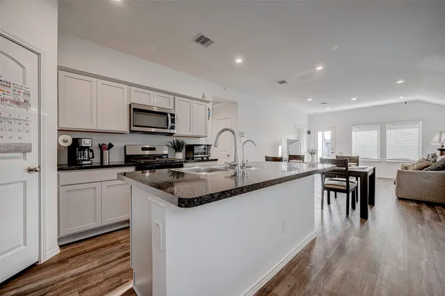 a kitchen with appliances a sink a counter top space and cabinets