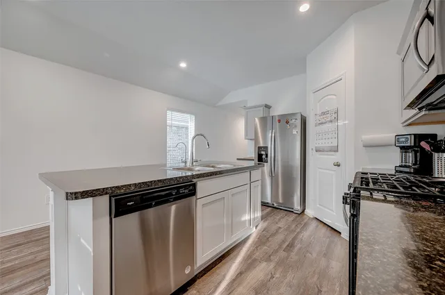 a kitchen with stainless steel appliances a stove a sink and a refrigerator