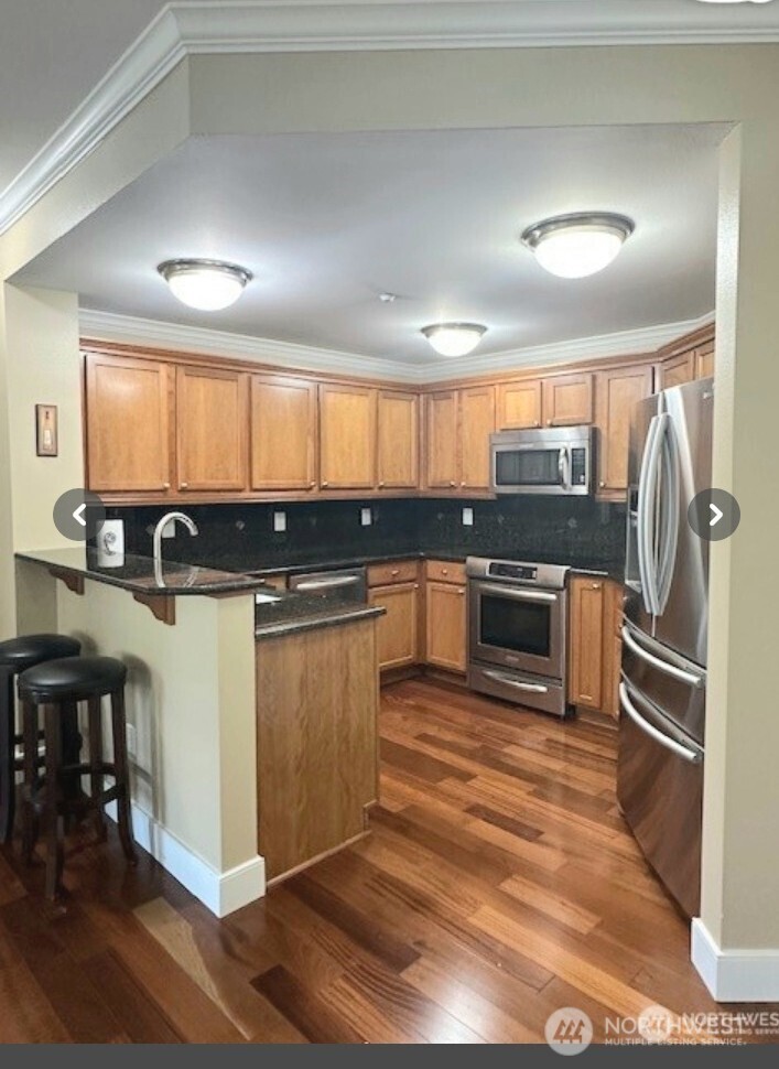 23943 Northeast 115th Lane, Unit 204 Redmond, WA 98053 - Photo 8 of 24 a kitchen with stainless steel appliances granite countertop a stove a sink and a microwave