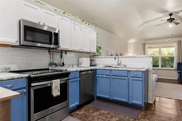 a kitchen with stainless steel appliances granite countertop a sink stove and microwave