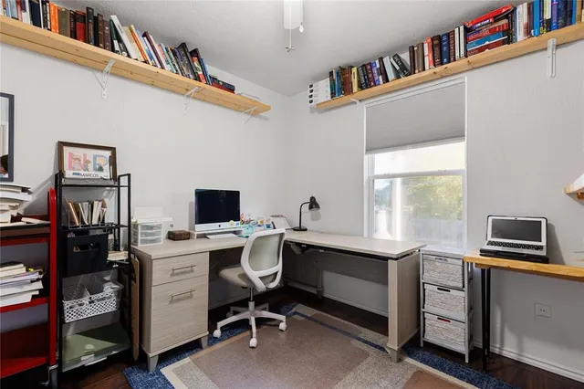 a view of a workspace with furniture and a window