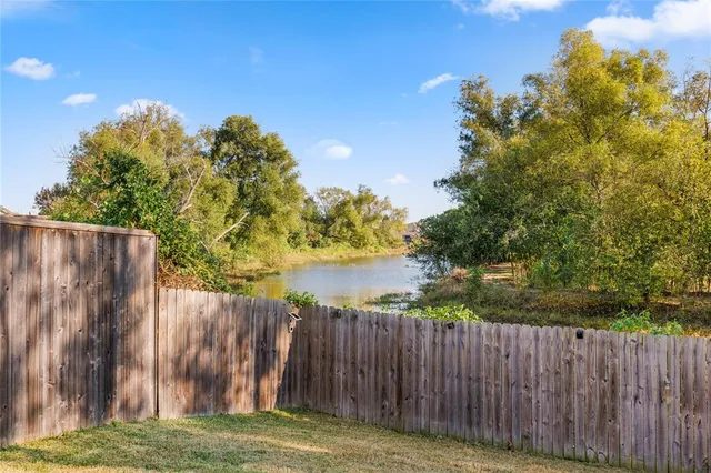 a view of a yard with wooden fence