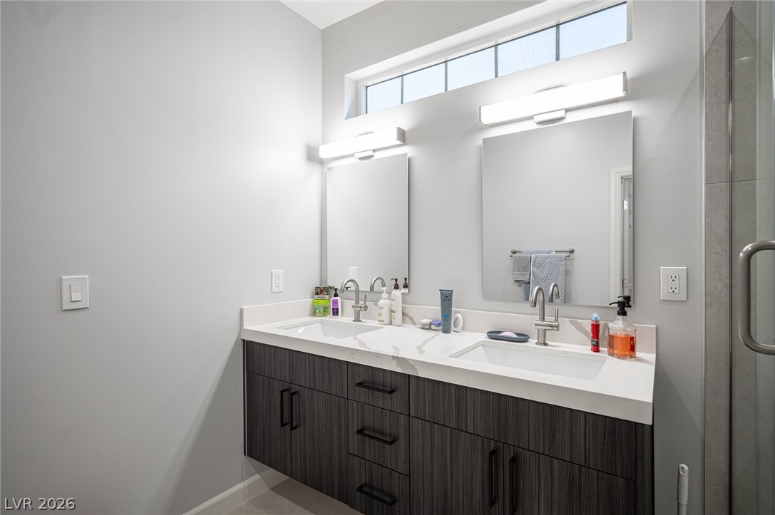441 Belville Road Pahrump, NV 89048 - Photo 31 of 44 Double vanity with sleek dark cabinetry and contemporary fixtures defines this primary bathroom.