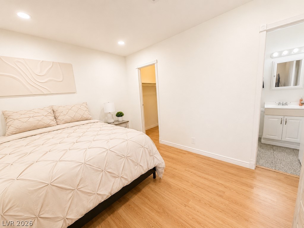 3010 East Viking Road Las Vegas, NV 89121 - Photo 36 of 48 Bright bedroom with warm hardwood floors and easy access to a private bathroom.