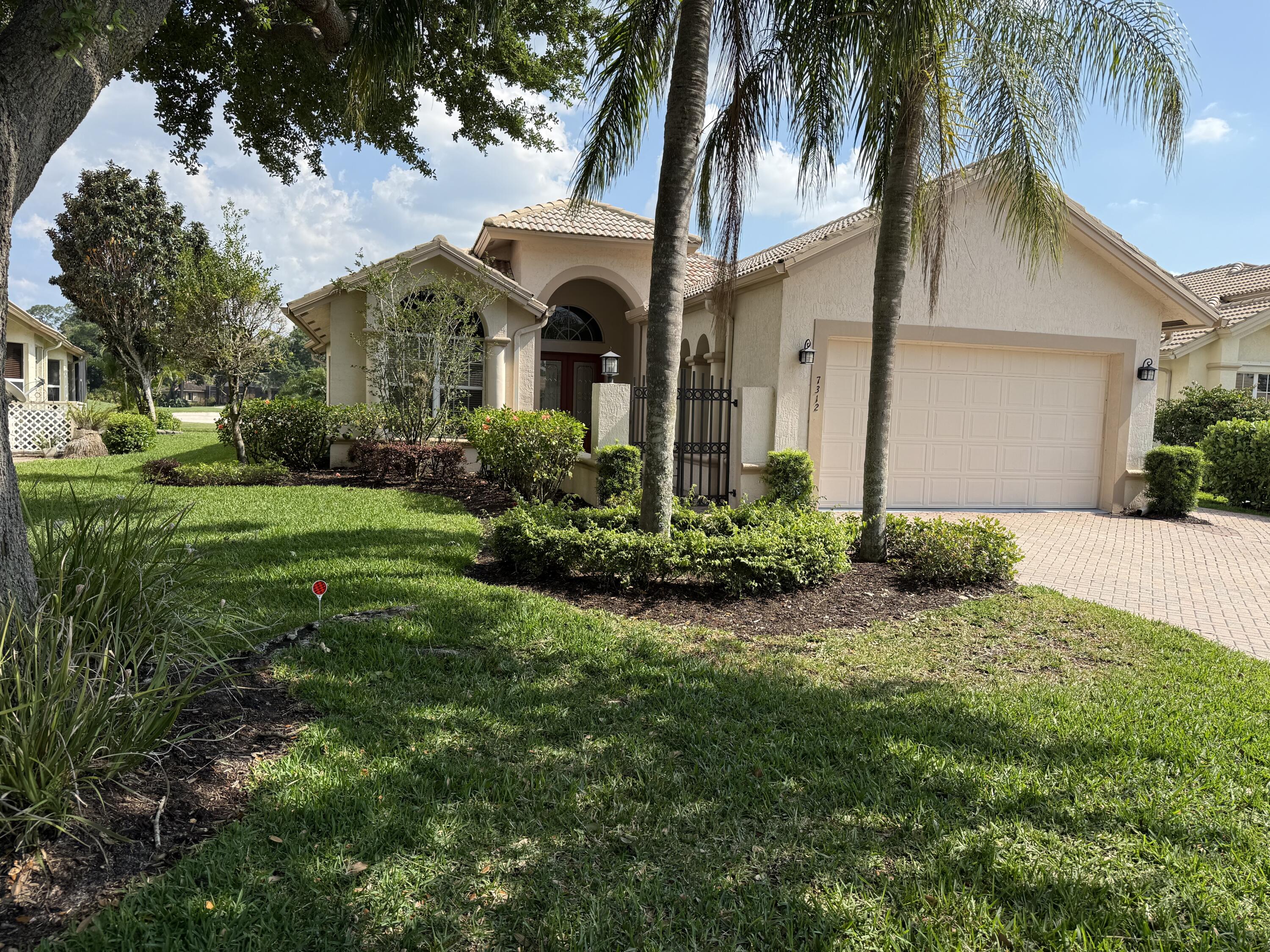 7312 Mystic Way Port St. Lucie, FL 34986 - Photo 1 of 8 a front view of a house with a garden