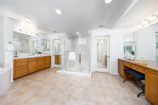 a large bathroom with a large tub sink vanity and mirror