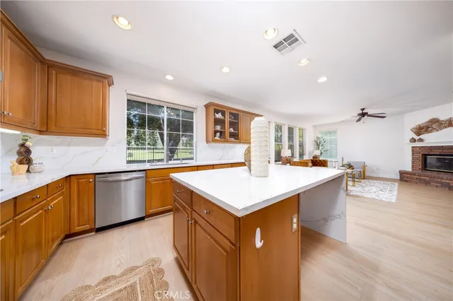 a kitchen with stainless steel appliances granite countertop a sink a stove and a wooden floors