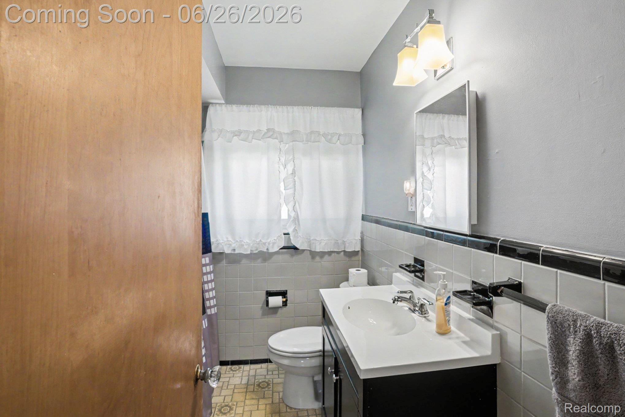 1209 Massoit Road Clawson, MI 48017 - Photo 18 of 25 Bathroom featuring a single-sink vanity with white countertop, chrome faucet, and integrated mirror