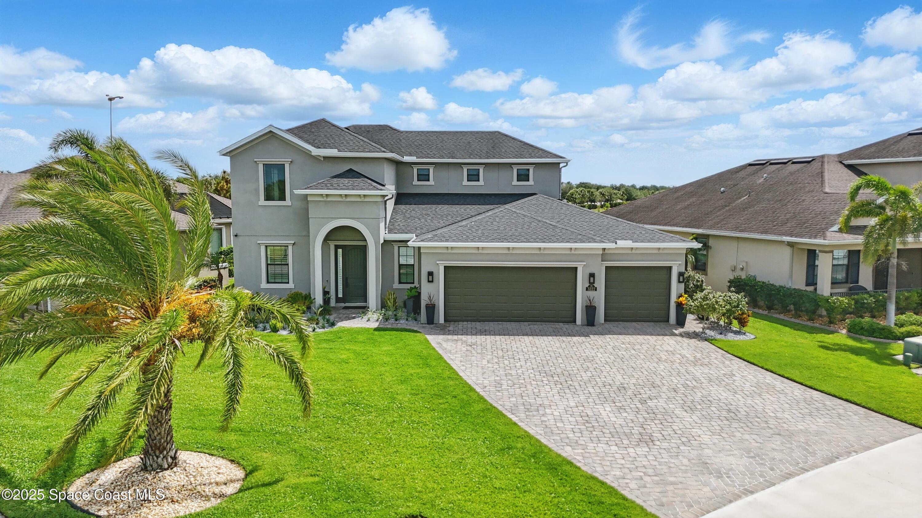 a front view of a house with a garden and yard
