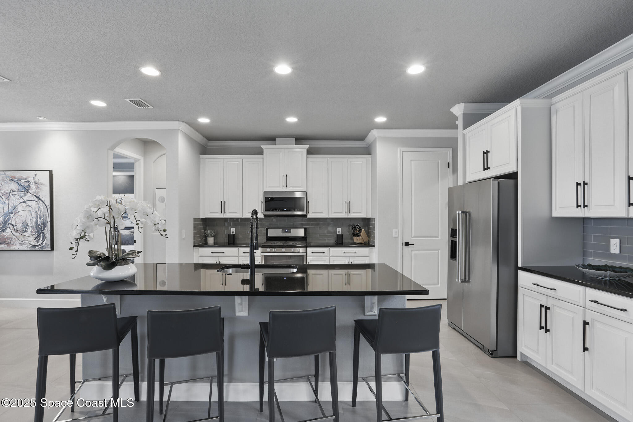 3222 Casterton Drive Melbourne, FL 32940 - Photo 12 of 67 a kitchen with stainless steel appliances granite countertop a table chairs refrigerator and a sink