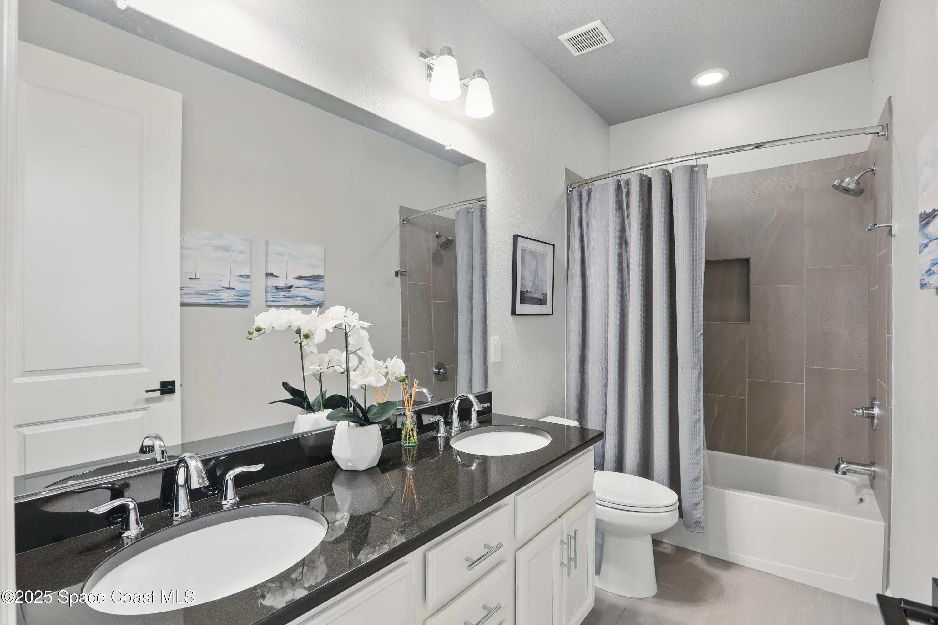 3222 Casterton Drive Melbourne, FL 32940 - Photo 29 of 67 a bathroom with a granite countertop sink toilet a large mirror a shower and a bathtub