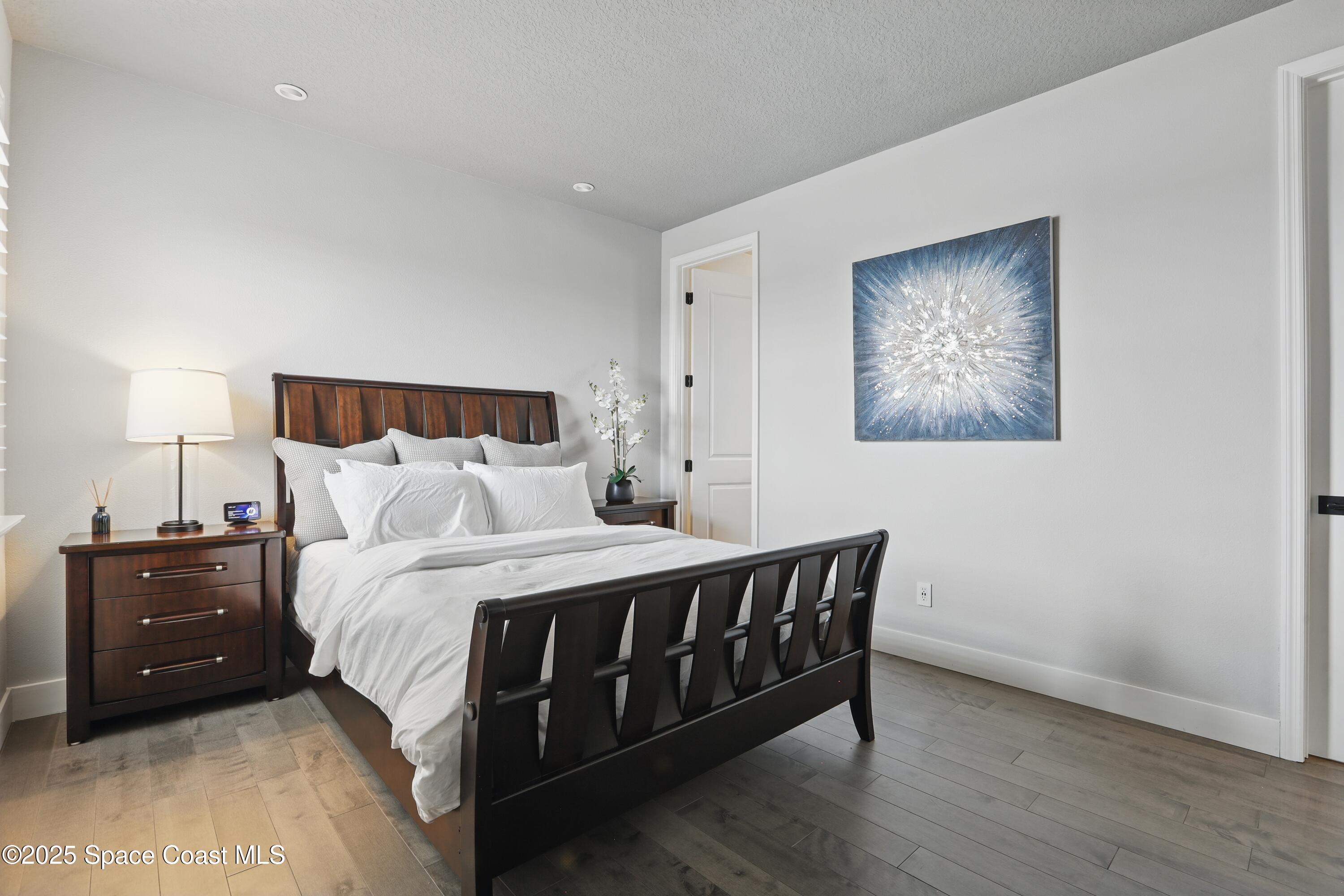 3222 Casterton Drive Melbourne, FL 32940 - Photo 32 of 67 a bedroom with a bed and a lamp on dresser