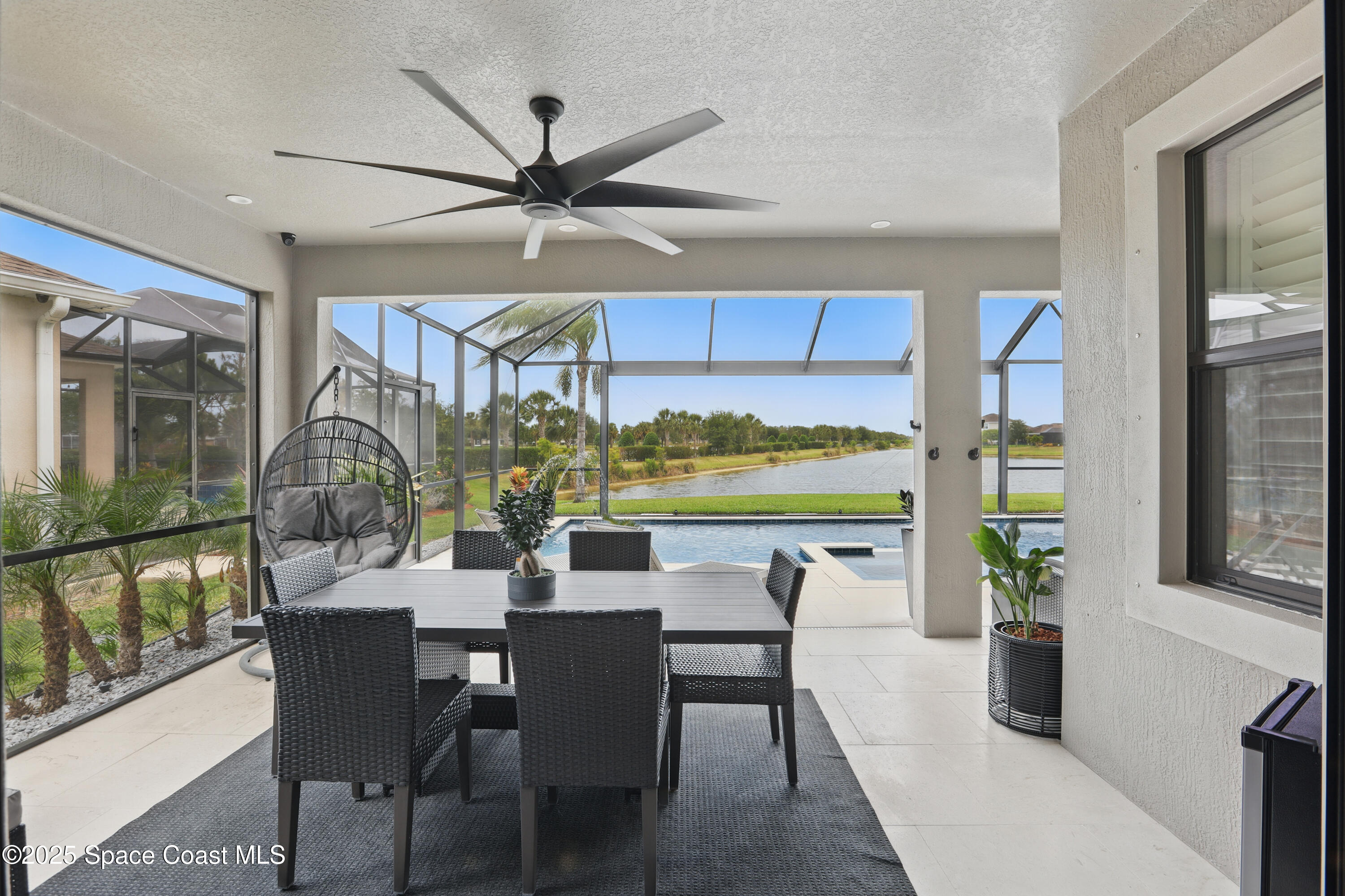 3222 Casterton Drive Melbourne, FL 32940 - Photo 38 of 67 a dining room with furniture a floor to ceiling window and potted plants
