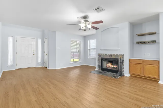 a view of empty room with wooden floor and fireplace