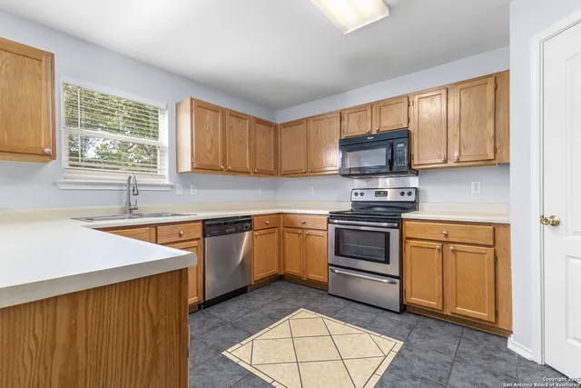 a kitchen with stainless steel appliances granite countertop a stove sink and microwave