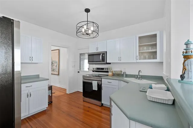 a kitchen with stainless steel appliances granite countertop a sink dishwasher stove and oven with wooden floor