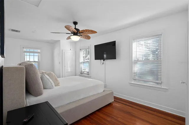 a bedroom with a bed a window and a flat screen tv