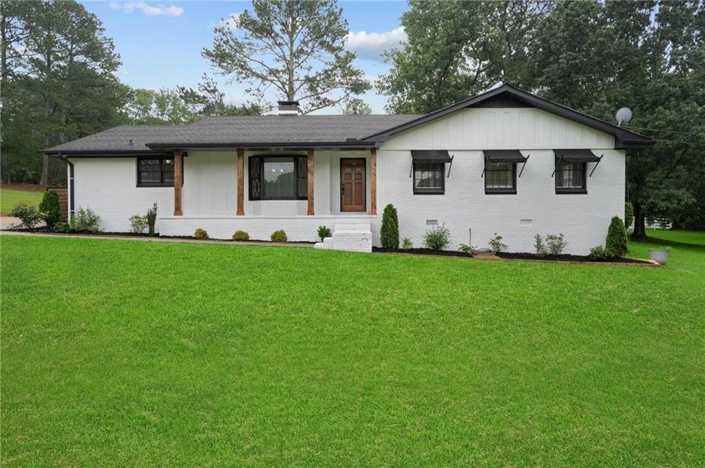 a view of a house with a yard and sitting area