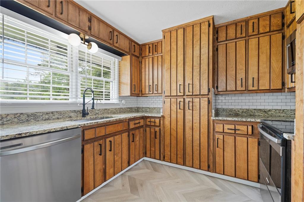 2827 Highway 138 Conyers, GA 30013 - Photo 31 of 32 a kitchen with stainless steel appliances granite countertop wooden cabinets a sink and a dishwasher