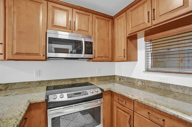 a kitchen with granite countertop a stove and a sink