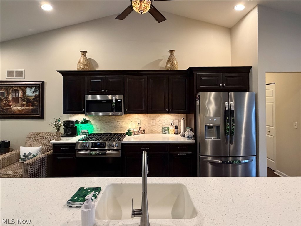 1343 Courtland Road Weirton, WV 26062 - Photo 8 of 50 Kitchen featuring stainless steel appliances, lofted ceiling, recessed lighting, backsplash, and dark wood finish cabinets