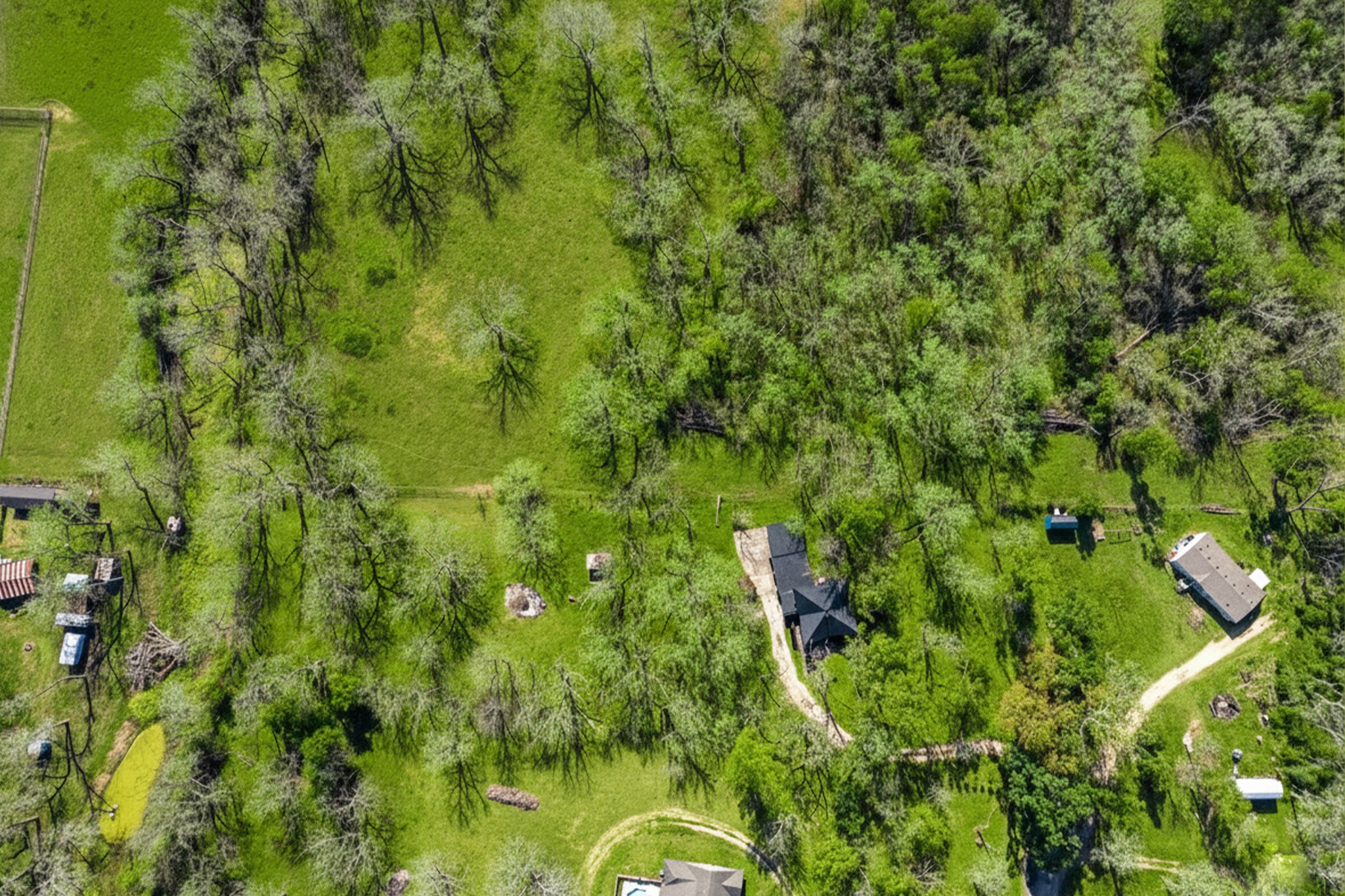 14311 Blidel Road Thompsons, TX 77469 - Photo 22 of 27 Elevated aerial perspective highlighting the home centered within a private, tree-lined property with long driveway and surrounding pastures.