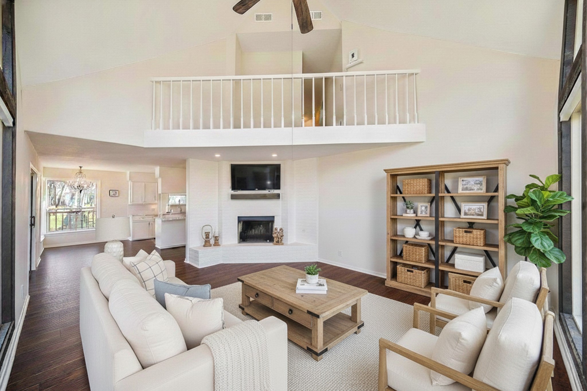 14311 Blidel Road Thompsons, TX 77469 - Photo 5 of 27 Open living room view showcasing fireplace, balcony overlook, the upgraded flooring, and connection to dining and kitchen areas.
