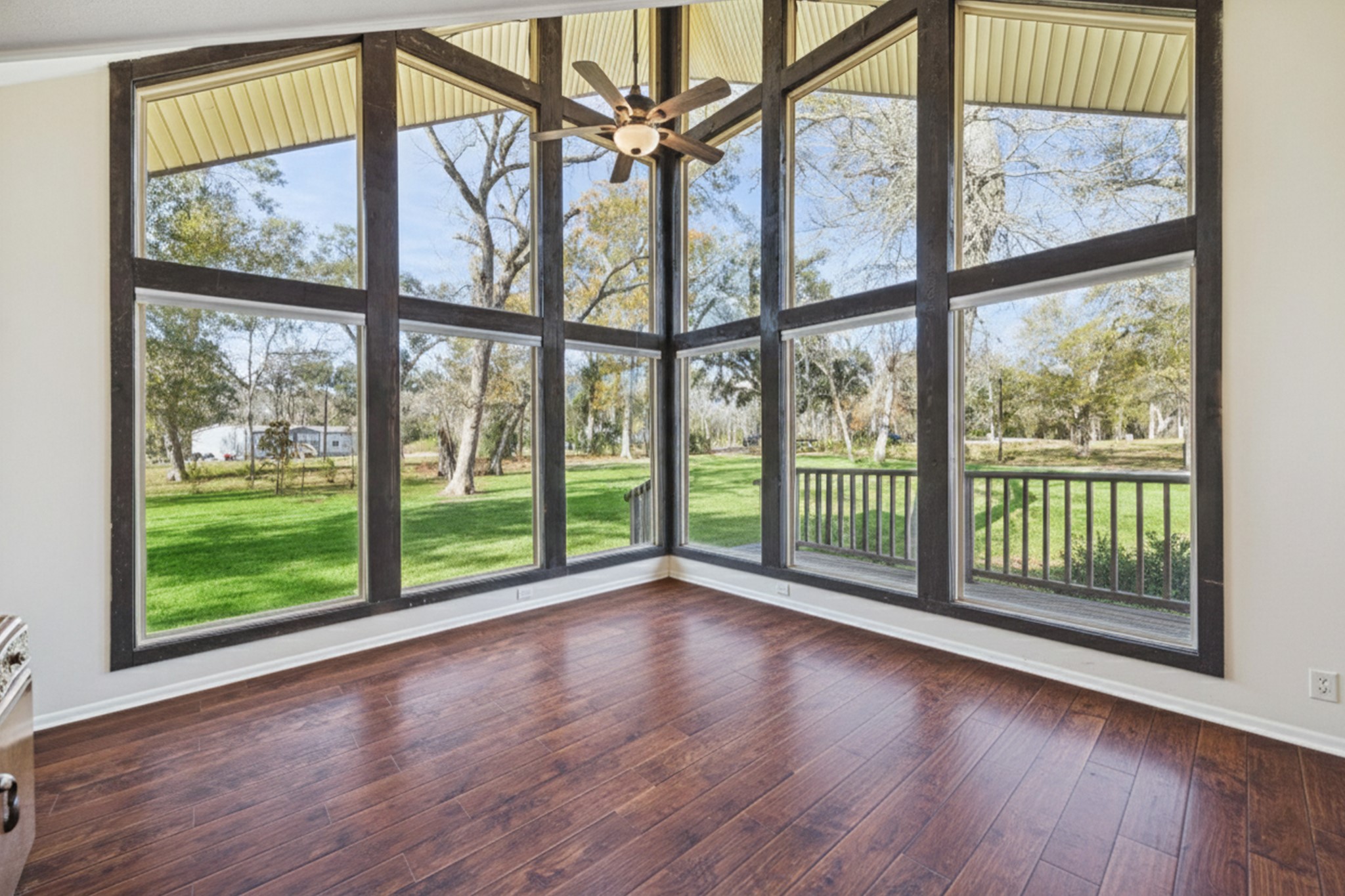 14311 Blidel Road Thompsons, TX 77469 - Photo 6 of 27 Alternate living area view highlighting wall of windows, open layout, the upgraded flooring, and scenic views of the property.