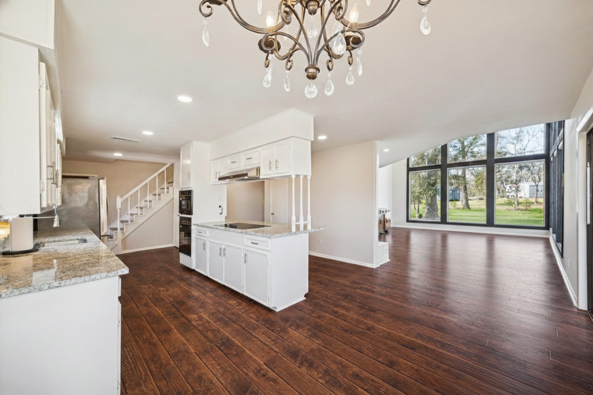 14311 Blidel Road Thompsons, TX 77469 - Photo 10 of 27 Alternate kitchen view displaying island seating, updated appliances, staircase access, and open flow to the living room.