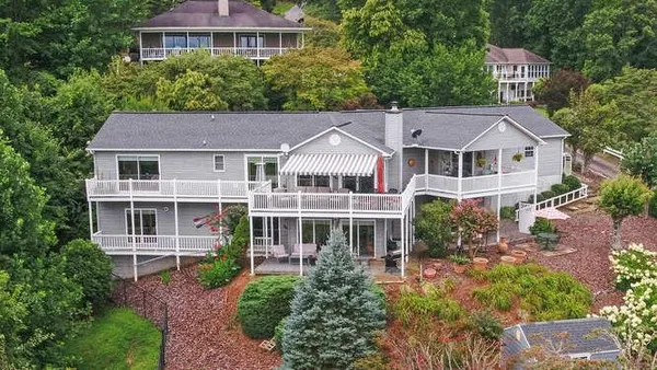 a front view of a house with a yard and potted plants