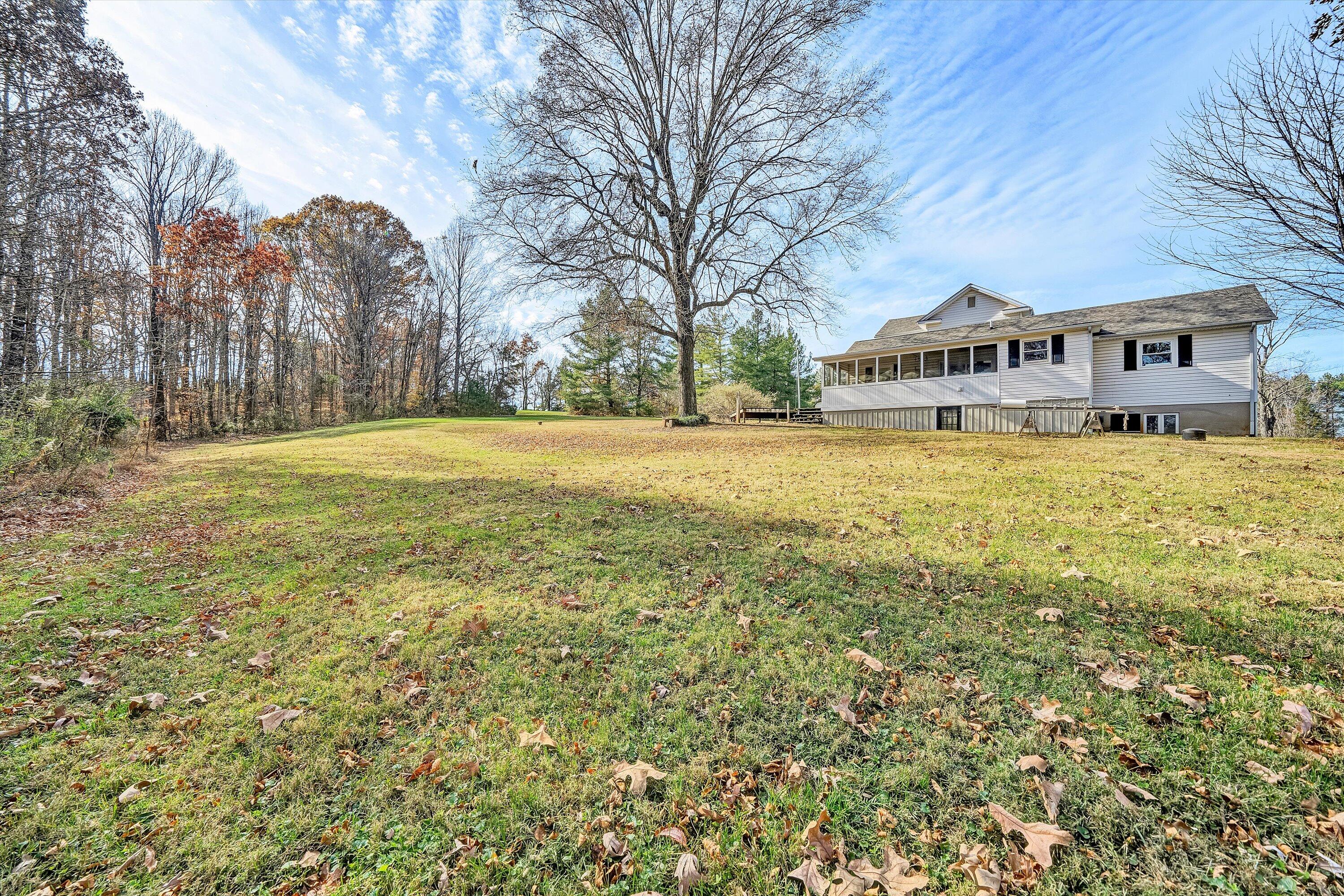 412 Wrays Chapel Road Rocky Mount, VA 24151 - Photo 21 of 25 a yellow house sitting in middle of a yard