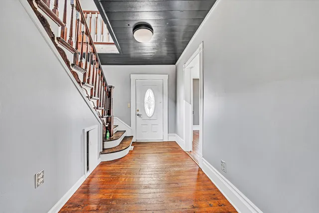 a view of entryway and hall with wooden floor