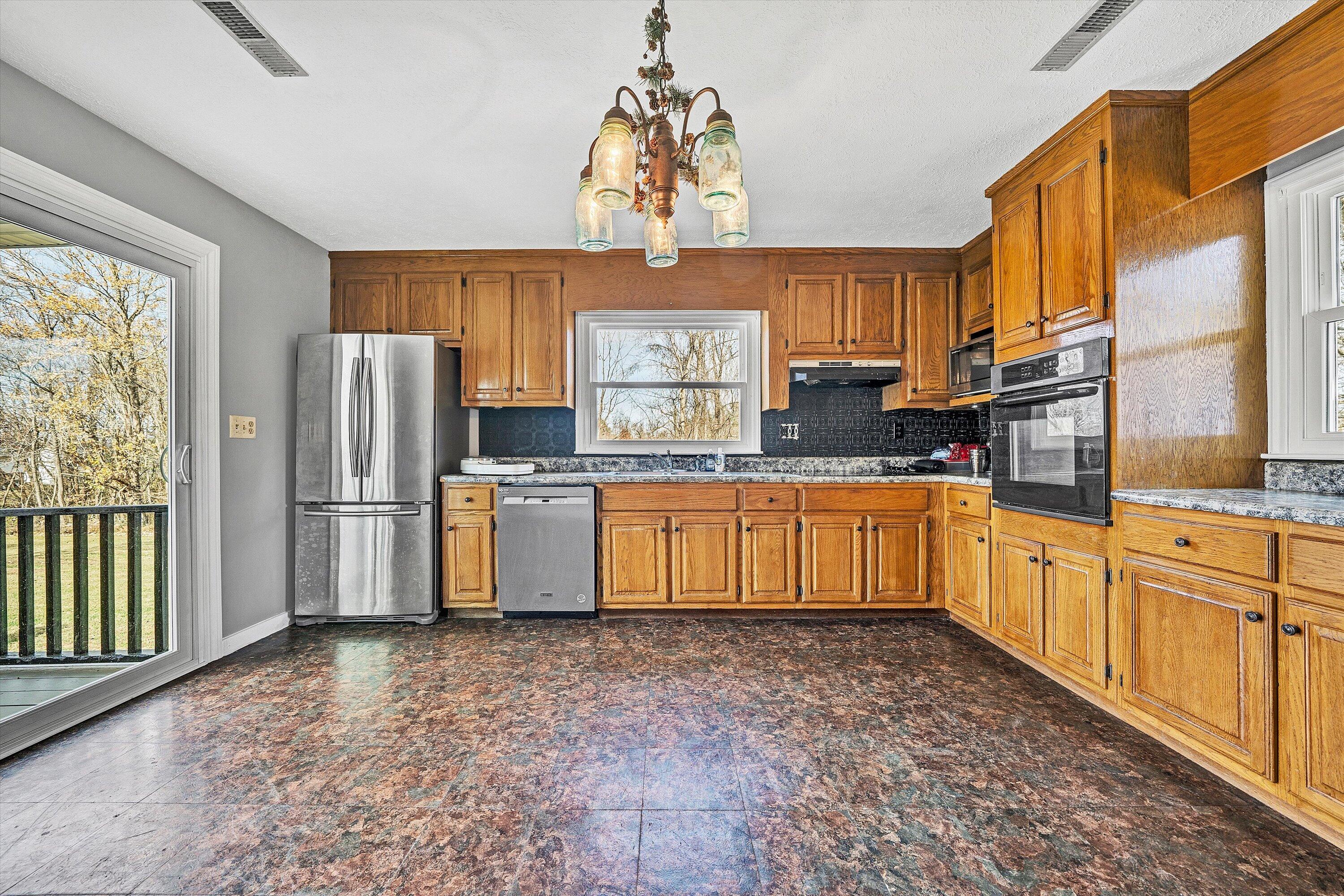 412 Wrays Chapel Road Rocky Mount, VA 24151 - Photo 7 of 25 a kitchen with stainless steel appliances granite countertop a sink a stove a refrigerator cabinets and a window